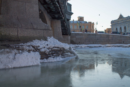 melting ice at the base of the bridge in early springの写真素材