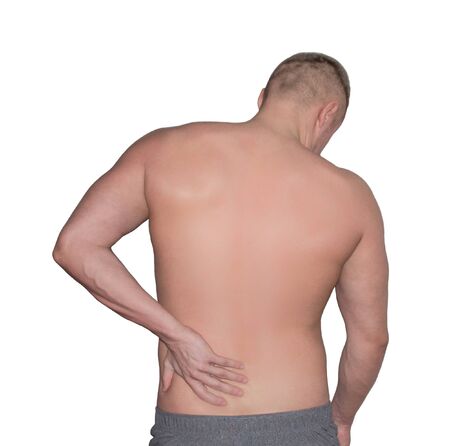 back pain. a man holds his hand on his lower backの写真素材