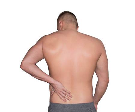 back pain. a man holds his hand on his lower backの写真素材