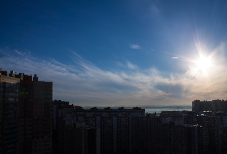 Morning sun in the blue sky over a cityの写真素材