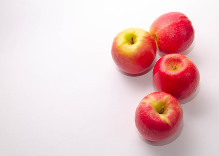 four red-yellow apples on a white backgroundの写真素材