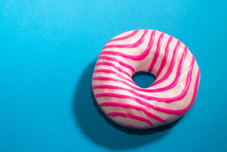 white pink donut close up on bright blue backgroundの写真素材