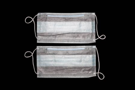 two disposable medical masks close up on a black backgroundの写真素材
