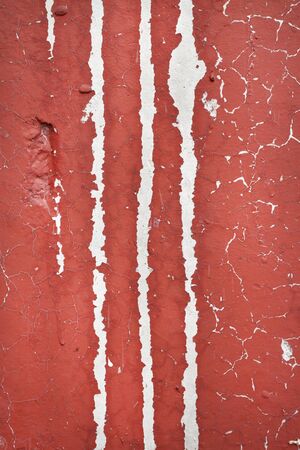 red painted concrete wall with long vertical cracks backgroundの写真素材
