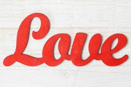 Red word LOVE isolated white shabby painted wooden background macroの写真素材