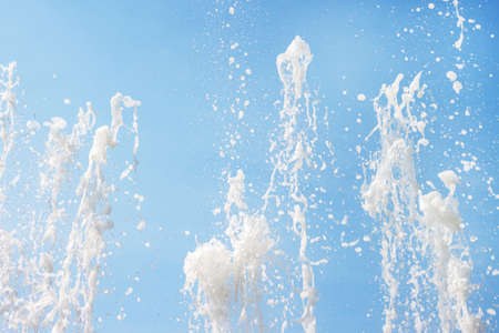 Flowing fountain water jets spray texture pattern with blue sky background macro wallpaperの写真素材