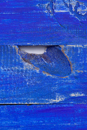 Shabby bright blue color painted wooden surface with hole for background or wallpaper macroの写真素材