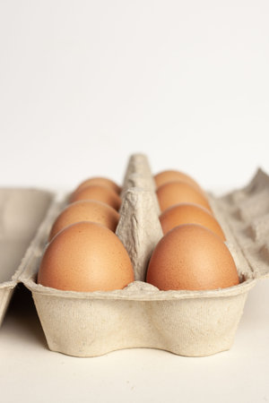 Cardboard package with not colored eggs isolated light background
