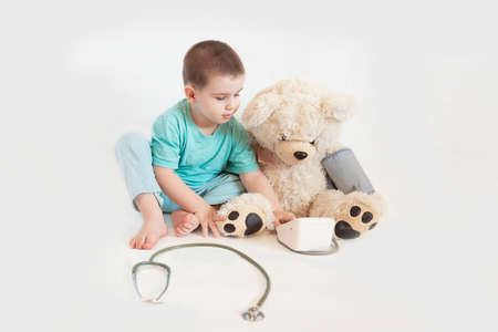 Adorable boy with clothes and stethoscope of doctor isolated on white backgroundのeditorial素材