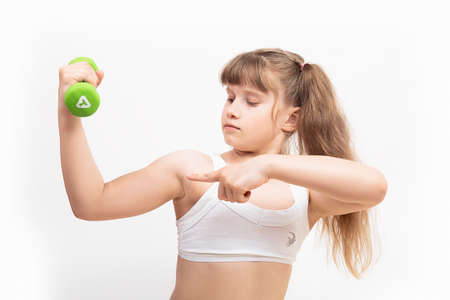 the girl is engaged in fitness, sports with green dumbbellsのeditorial素材