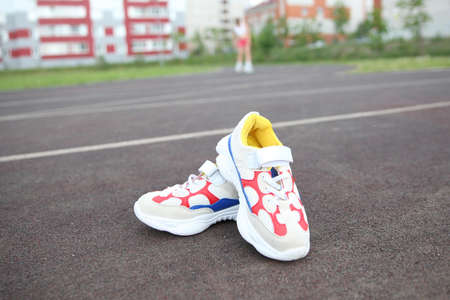 colored athletic sneakers or boots lie on the background of a brown treadmillのeditorial素材