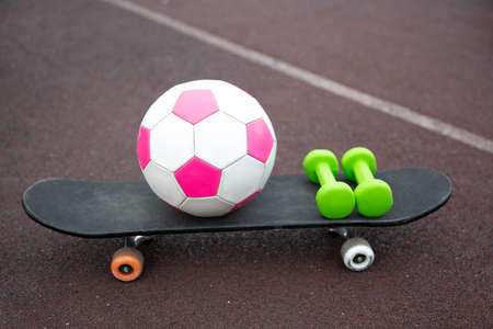 pink soccer ball, dumbbells, skateboard isolated on the treadmill. The concept of sports lifestyle.のeditorial素材