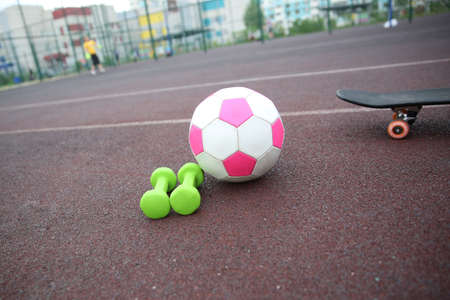 pink soccer ball, dumbbells, skateboard isolated on the treadmill. The concept of sports lifestyle.のeditorial素材