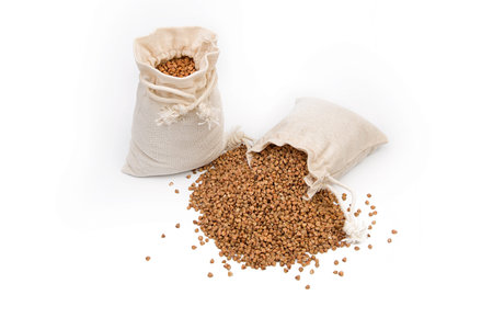 Raw buckwheat in a linen or jute bag on a white background