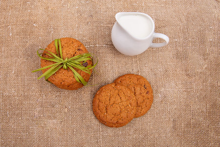 Oatmeal cookies with milk on old burlap