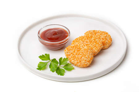 A pile of cooked chicken nuggets in a plate with tomato sauce, isolated on a white backgroundの写真素材
