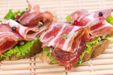 Canapes with ham on a straw matの写真素材