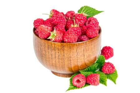 Ripe raspberries in wooden bowl isolated on white background