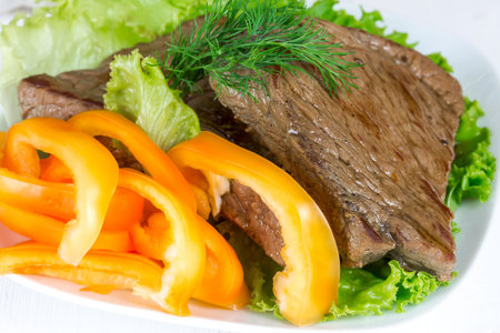Grilled beef on lettuce leaves with vegetablesの写真素材