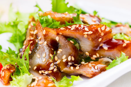 Salad with smoked eel in the unagi sauce and sesame seeds.の写真素材