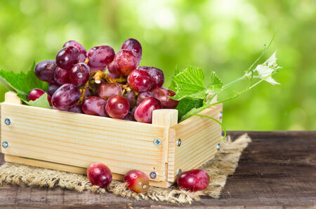 Ripe red grapes in a wooden boxの写真素材