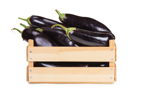 Ripe eggplant in a wooden box isolated on white background. の写真素材
