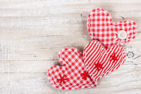 Three decorative fabric heart for Valentines day on a wooden backgroundの写真素材