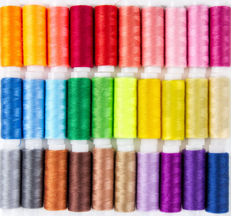 Background from bobbins with multicolored thread for sewing