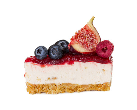 Piece of cheesecake with jam, fresh blueberries, figs and raspberries isolated on white background.の写真素材