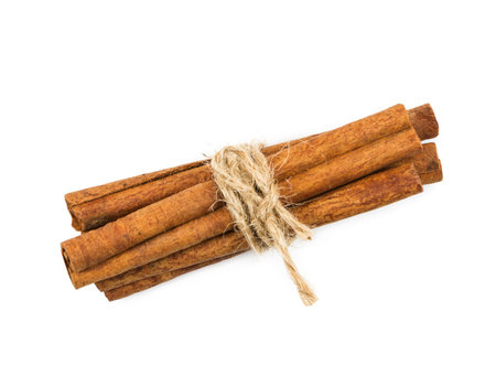 Cinnamon sticks tied with string, isolated on white background