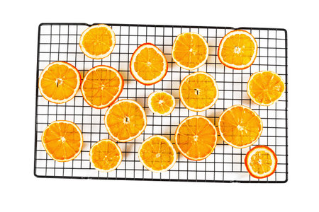 Dried thin translucent orange slices on pastry rack isolated on white background. Top view.