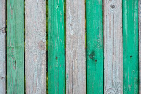 The old striped wooden fence is green.の写真素材