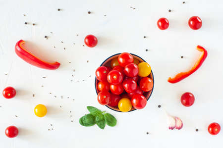 Pepper, cherry tomatoes yellow and red, spices on a white background. View from above. Copy space.の写真素材
