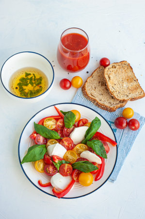 Salad with tomatoes, peppers, mozzarella. Tomato juice and toast.