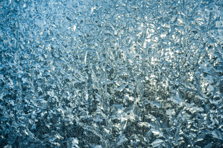 Frosty patterns on the window at dawn. Frosty window texture. Abstract background.の写真素材