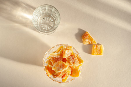 Pieces of dried mango in a glass plate in bright sunlight. mango candied. Unusual sweets. Healthy sweets.の写真素材