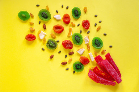 Composition of multicolored candied fruit on a yellow background. View from above. A place for text.