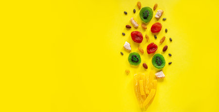Composition of multicolored candied fruit on a yellow background. View from above. A place for text.