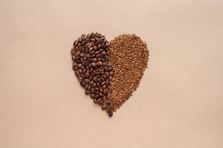 The heart is laid out from roasted coffee beans and instant granulated coffee on a beige background. Monochrome. Love for coffee. Copy spaceの写真素材