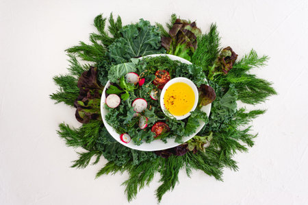 Kale cabbage salad, herbs, tomatoes and radishes in a white oval plate with ingredients around on a...