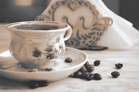 Beautiful vintage cup of coffee and coffee beans on the tableの写真素材