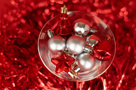 Christmas silver and red toys in a glass goblet on a red backgroundの写真素材