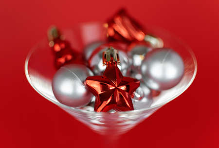 Christmas silver and red toys in a glass goblet on a red backgroundの写真素材