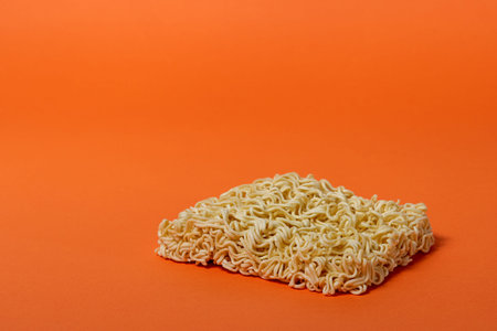 Cheap dry Chinese noodles without box, on orange background, side view, isolateの写真素材