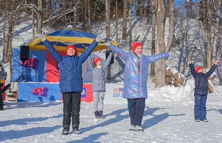 RUSSIA, YAROSLAVL - FEBRUARY 22, 2021. Winter holiday Dad's Day in the forest entertainment Park Zabava - children's team dances in front of the audienceのeditorial素材
