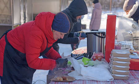 RUSSIA, YAROSLAVL - FEBRUARY 22, 2021. Winter holiday Dad's Day in the forest entertainment Park Zabava - sale of ready-made food burgers and shish kebab for holiday participantsのeditorial素材