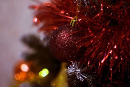 Bright red New Year's toys vests on the branches of a Christmas tree with decorationsの写真素材