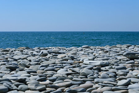 Gray stones on the seashore against the blue sky