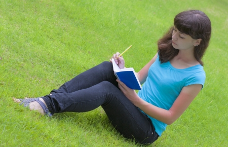 girl student with notebook on the grassの写真素材