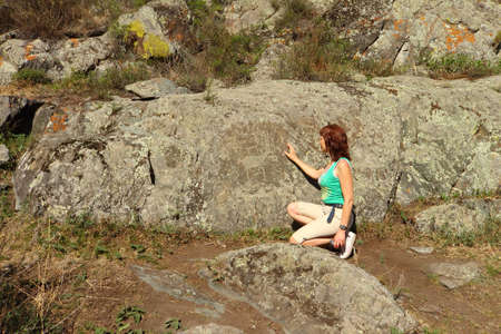 The woman considers rock paintings of ancient peopleの写真素材
